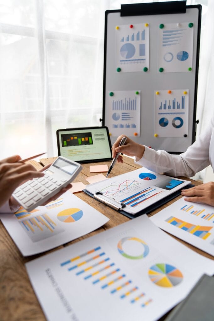 Financial analysts analyze business financial reports on digital tablets during conversations at cor